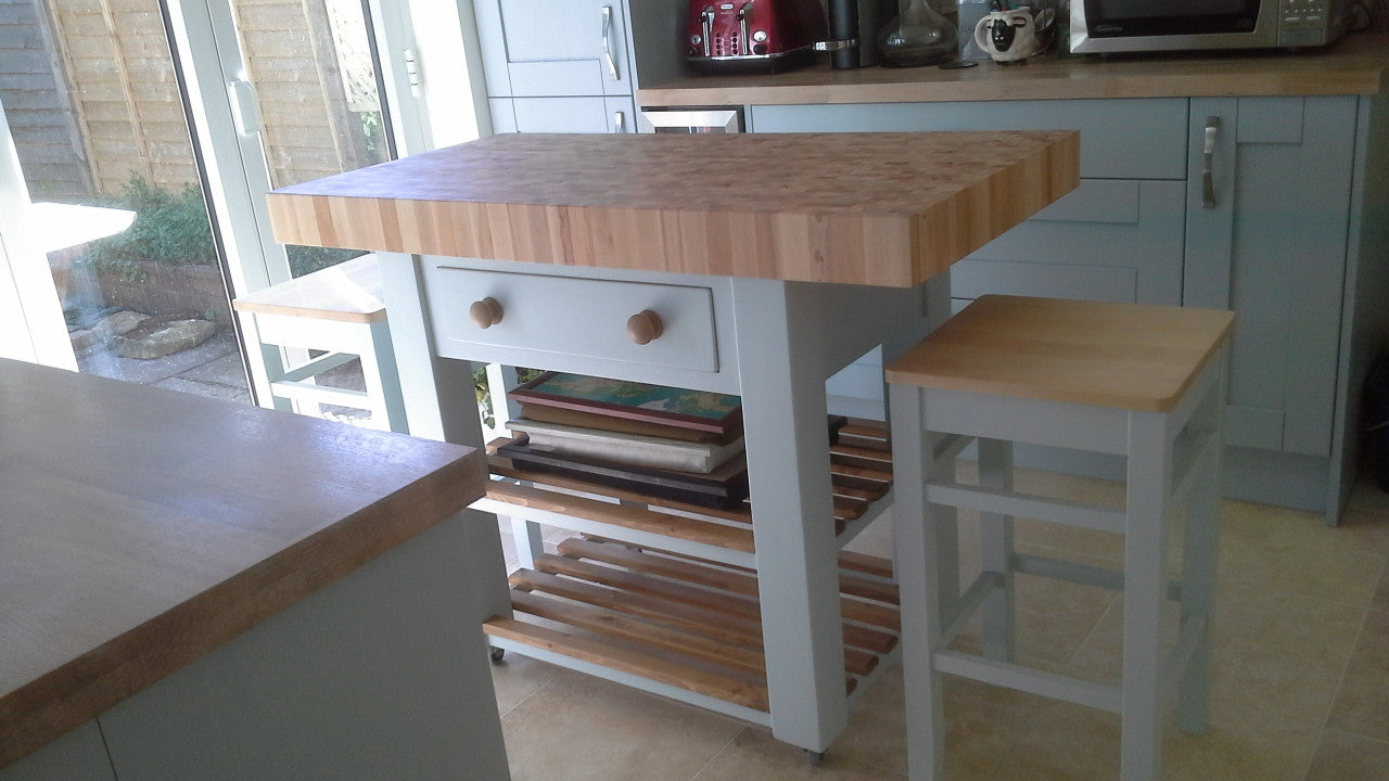 Kitchen island with wooden top and stools in a home setting