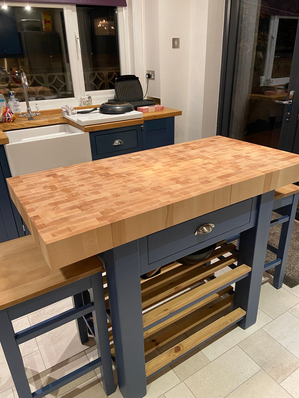 Kitchen island with wooden countertop and blue base in a home setting