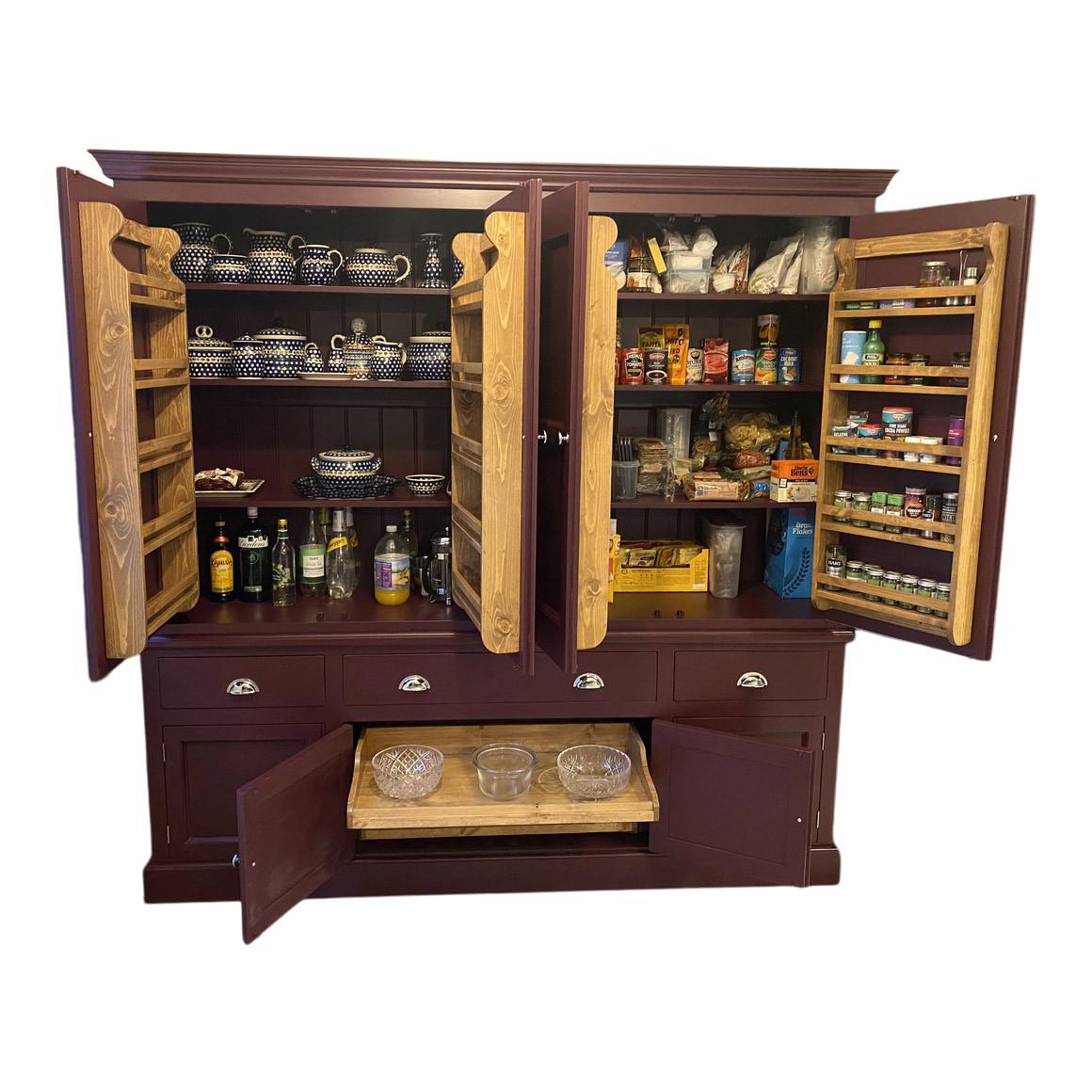 Wooden pantry cabinet with open doors displaying various items on a white background